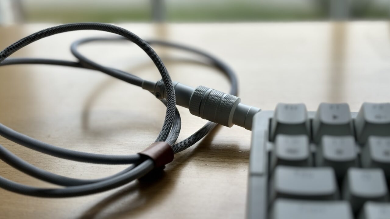 Desk cables routed beside a keyboard for a clean standing desk