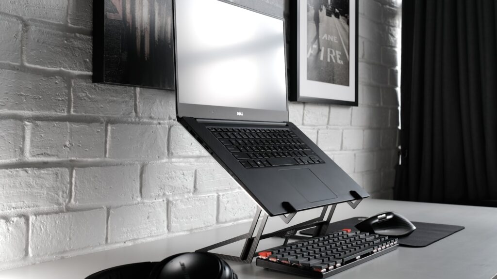 Laptop stand with external keyboard and mouse on a desk